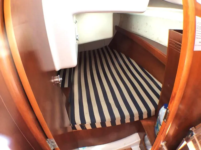Slide: The Image of 2003 Beneteau First cabin interior with striped mattress and wooden finish. - 15