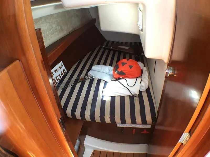 Slide: The Image of 2003 Beneteau First cabin with striped bedding and nautical decor. - 16