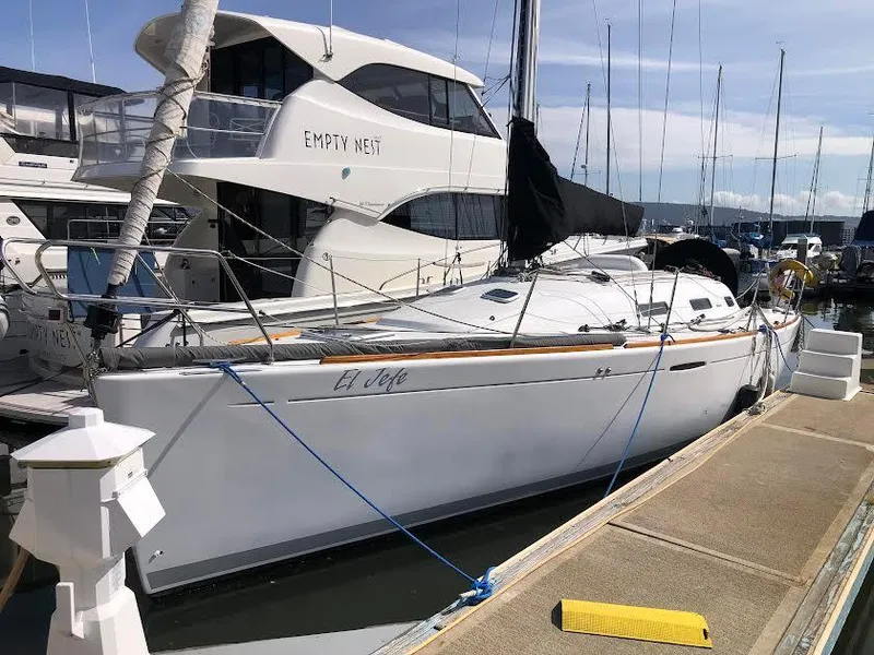 Slide: The Image of 2003 Beneteau First sailboat docked at marina, adjacent to larger yacht. - 3