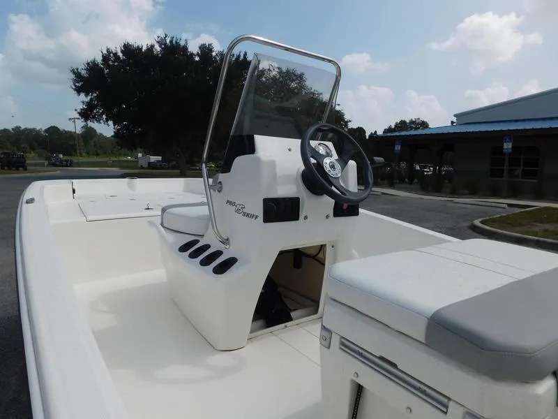 Slide: The Image of 2023 Mako Pro Skiff 15 CC boat with center console and steering wheel. - 4