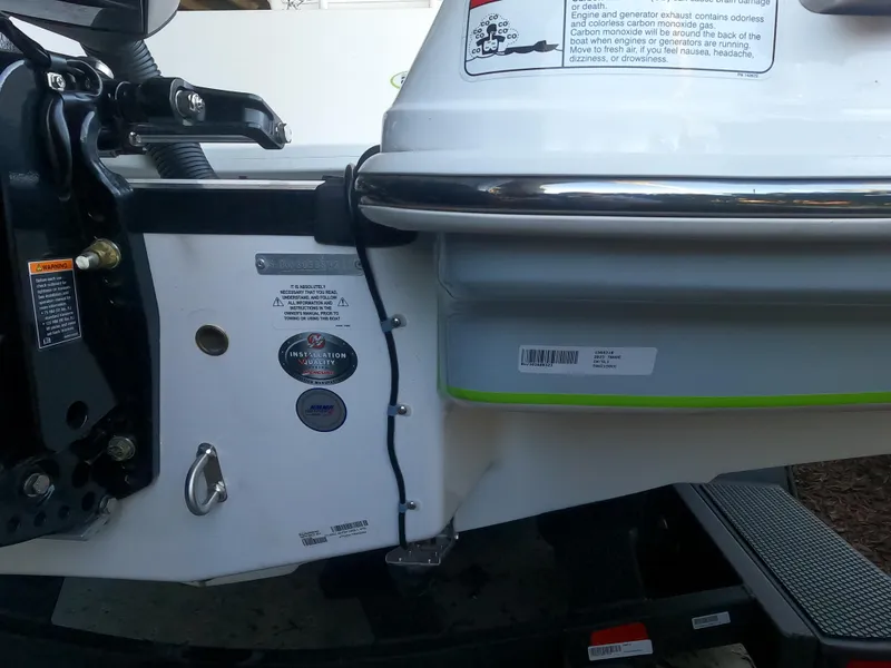 Slide: The Image of Close-up of 2023 Tahoe 2150 CC boat's rear section with labels and hardware. - 10