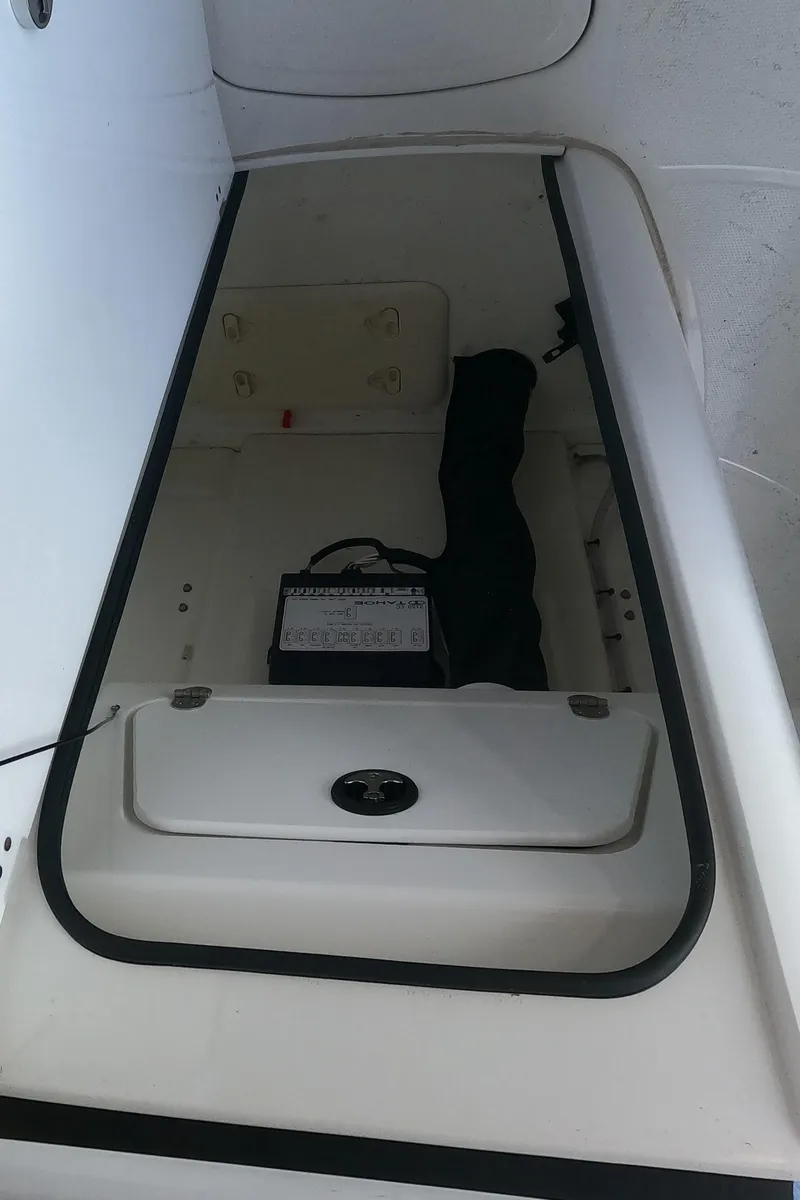 Slide: The Image of 2023 Tahoe 2150 CC boat storage compartment with battery. - 11