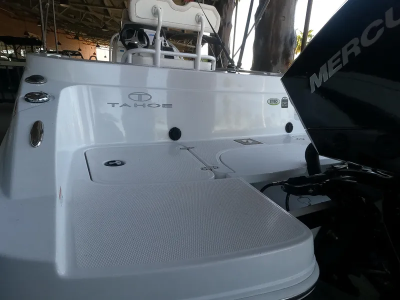 Slide: The Image of 2023 Tahoe 2150 CC boat with Mercury engine, rear view in a covered dock. - 2