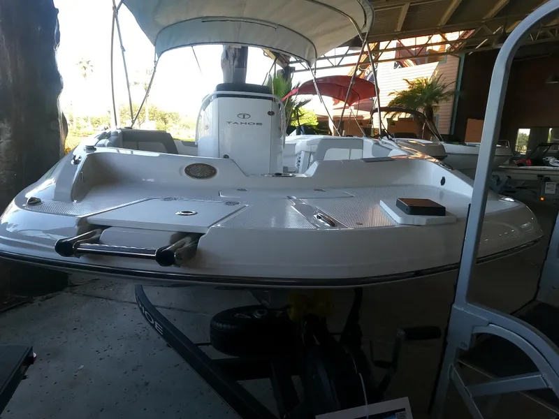 Slide: The Image of 2023 Tahoe 2150 CC boat with canopy in a covered dock area. - 5