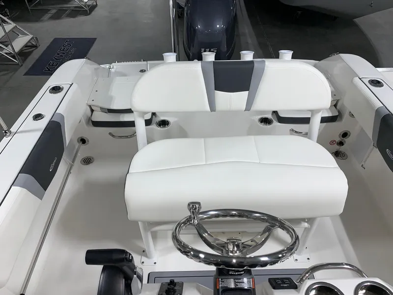 Slide: The Image of 2024 Robalo R180 Center Console boat interior with white seating and steering wheel. - 9