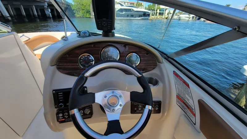 Slide: The Image of 2007 Sea Ray SunDeck 200 boat dashboard with steering wheel and gauges, docked by the water. - 16