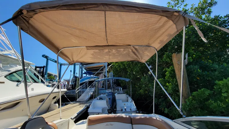 Slide: The Image of 2007 Sea Ray SunDeck 200 with canopy, docked near other boats. - 31
