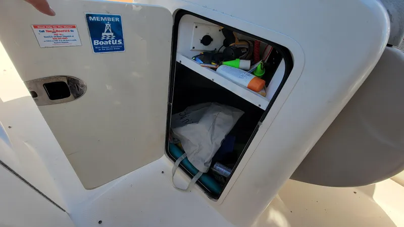 Slide: The Image of Open storage compartment on 2007 Sea Ray SunDeck 200 boat with various items inside. - 32