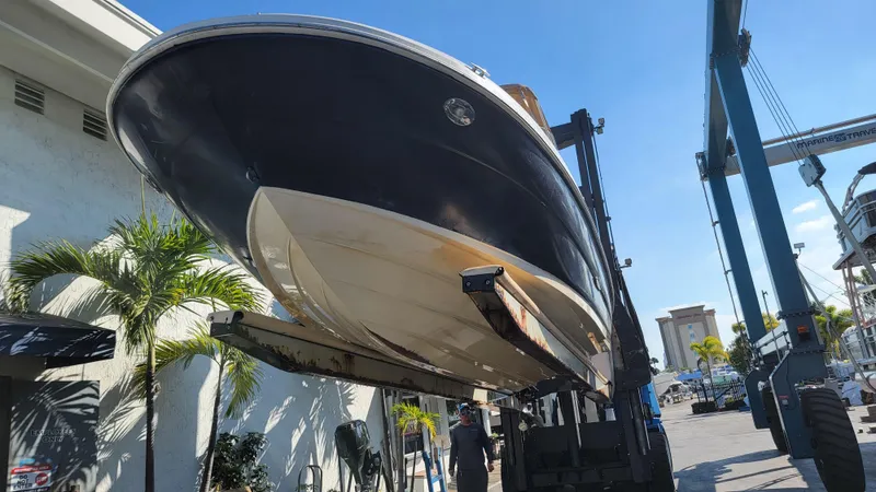 Slide: The Image of 2007 Sea Ray SunDeck 200 boat lifted at marina under clear blue sky. - 35