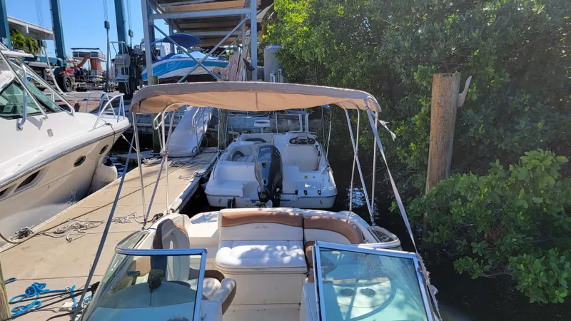 Slide: The Image of 2007 Sea Ray SunDeck 200 docked at marina, surrounded by greenery and other boats. - 48