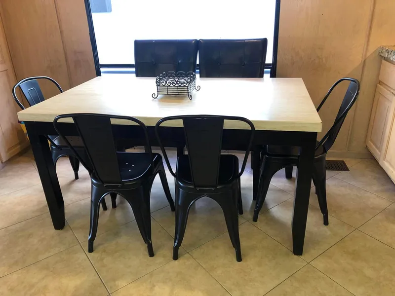 Slide: The Image of Dining table with black metal chairs in a modern kitchen setting. - 6