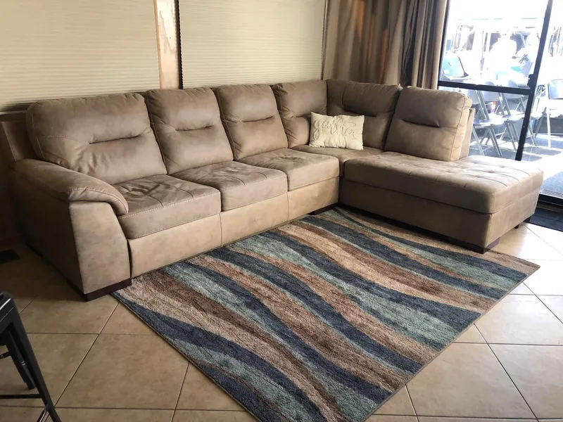 Slide: The Image of Beige sectional sofa on patterned rug in a cozy living space. - 7