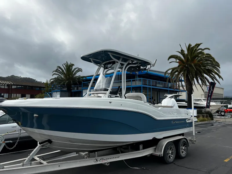 Slide: The Image of 2023 Finseeker 230 CC boat on trailer, parked near palm trees and buildings. - 10