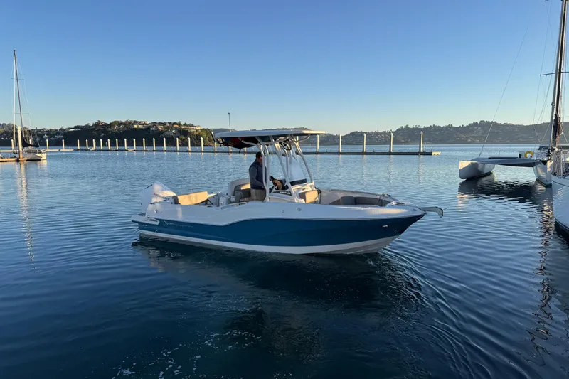 Slide: The Image of 2023 Finseeker 230 CC boat on calm water near a marina. - 25