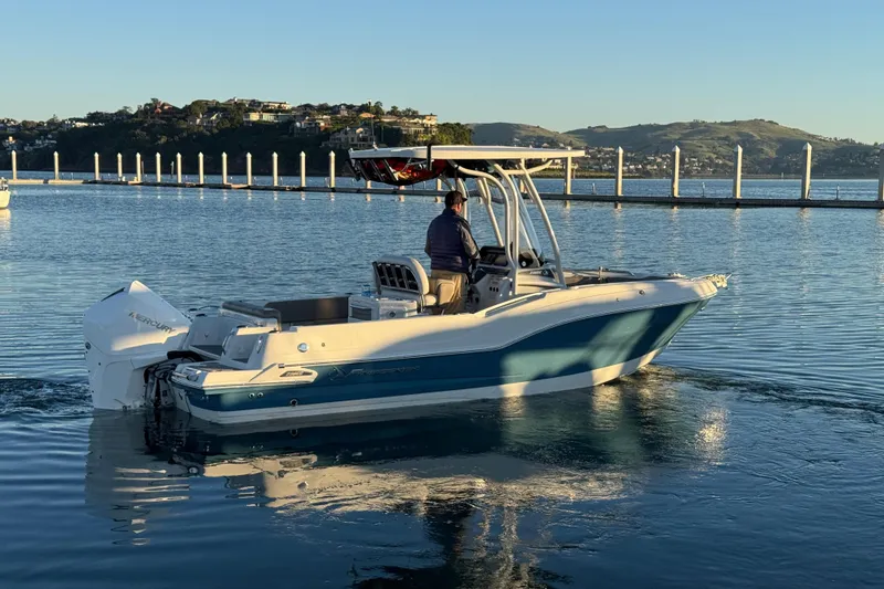 Slide: The Image of 2023 Finseeker 230 CC boat cruising on calm water near a scenic shoreline. - 26