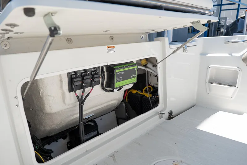 Slide: The Image of Open storage compartment of 2023 Finseeker 230 CC boat showing electrical components. - 9