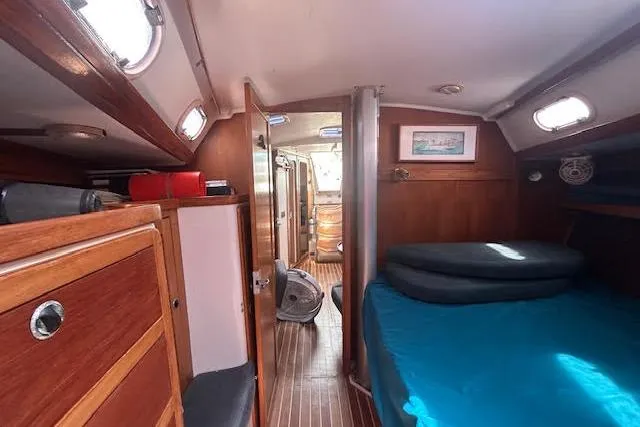 Slide: The Image of Interior of a 2000 Catalina 42 Mk II sailboat, featuring a cozy cabin with wood finishes. - 17