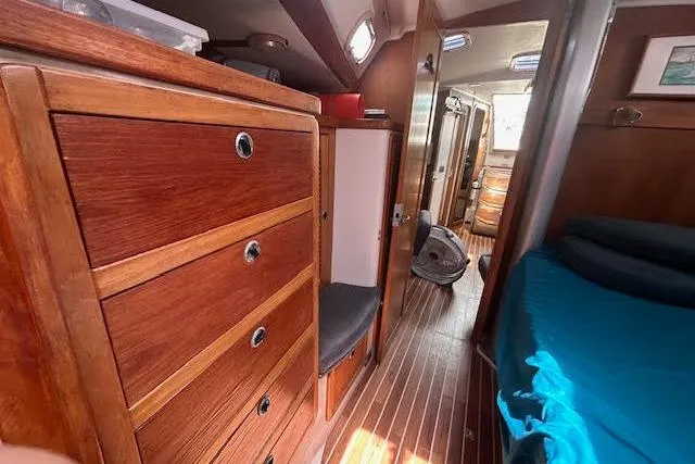 Slide: The Image of Interior of 2000 Catalina 42 Mk II sailboat with wooden cabinetry and blue bedding. - 21
