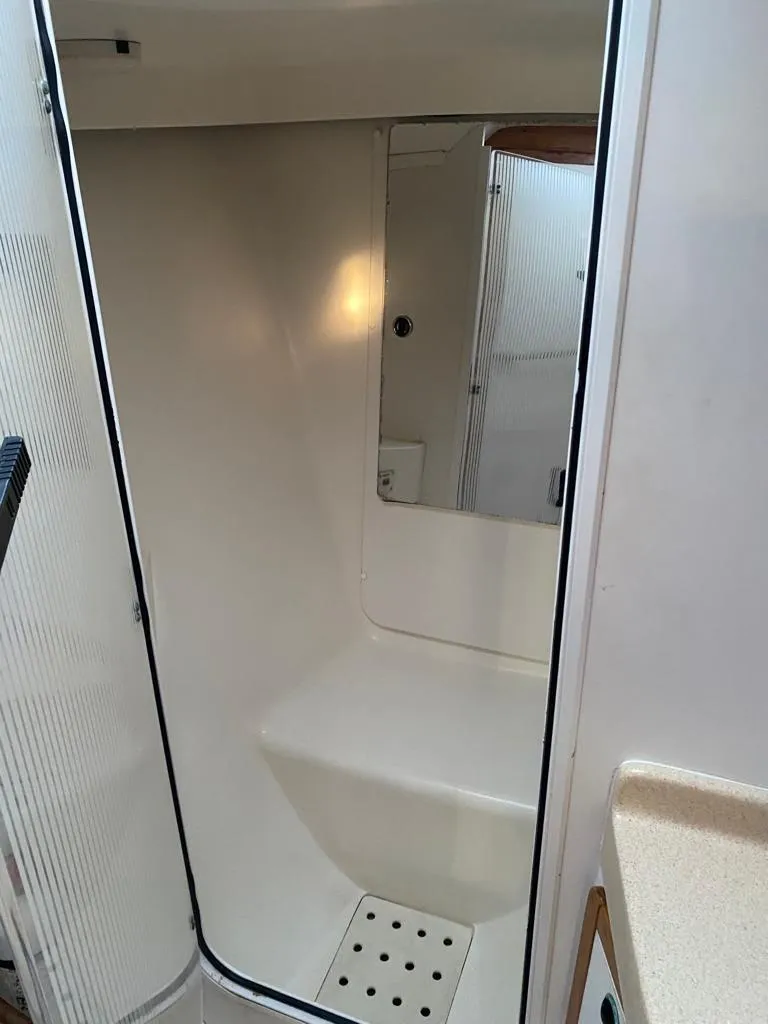 Slide: The Image of 2000 Catalina 42 Mk II sailboat interior shower area with white walls and built-in seat. - 8