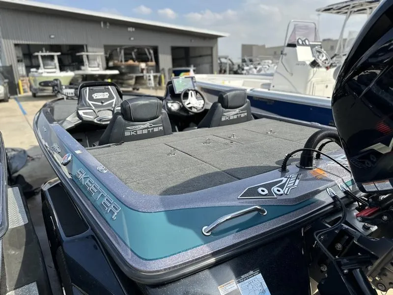 Slide: The Image of 2019 Skeeter FX21 LE boat at a marina, showcasing seating and deck. - 14