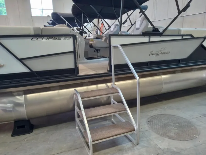 The Image of 2023 SunChaser Eclipse 8523 LR DH pontoon boat in showroom with boarding steps. - 0