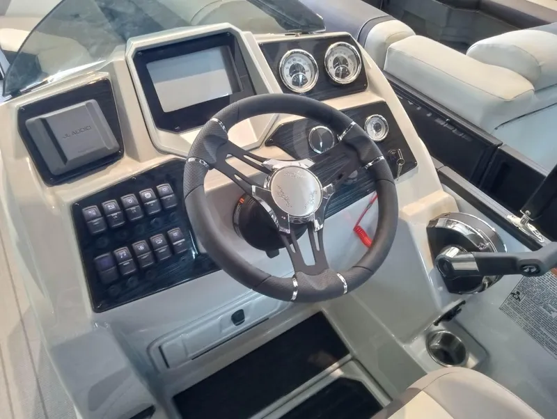 Slide: The Image of 2023 SunChaser Eclipse 8523 LR DH boat dashboard with steering wheel and control panel. - 2