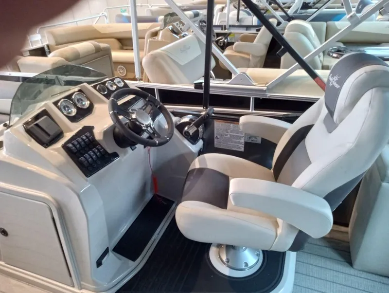 Slide: The Image of 2023 SunChaser Geneva Sport 25 SB boat interior with captain's chair and control panel. - 2