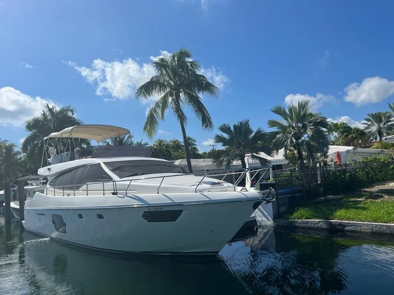 Slide: The Image of 2012 Ferretti Yachts 530 docked by palm trees under a clear blue sky. - 2