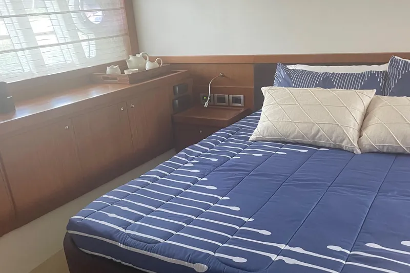 Slide: The Image of Luxurious bedroom interior of 2012 Ferretti Yachts 530 with blue bedding and wooden accents. - 8