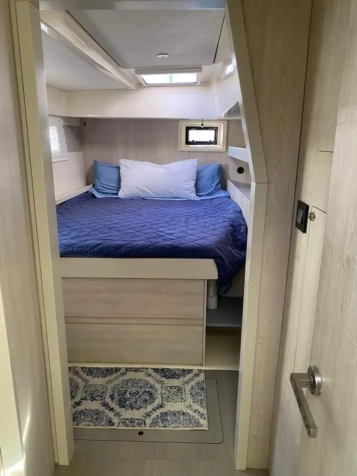 Slide: The Image of Cozy bedroom in 2016 Leopard 48 yacht with blue bedding and natural light. - 22