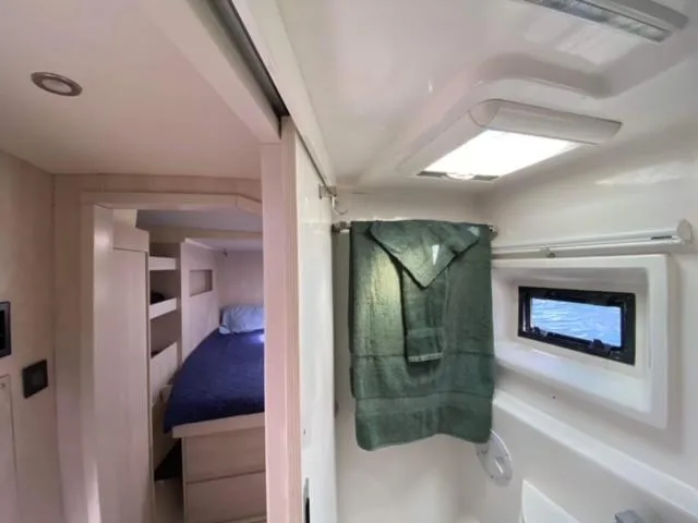 Slide: The Image of Interior of a 2016 Leopard 48 yacht showing a cozy bedroom and bathroom. - 31