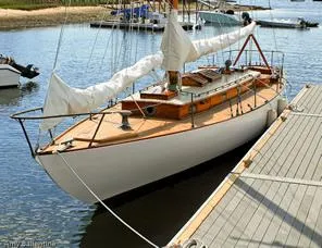 Slide: The Image of 1929 Herreshoff Fishers Island 31 sailboat docked in a serene marina setting. - 1