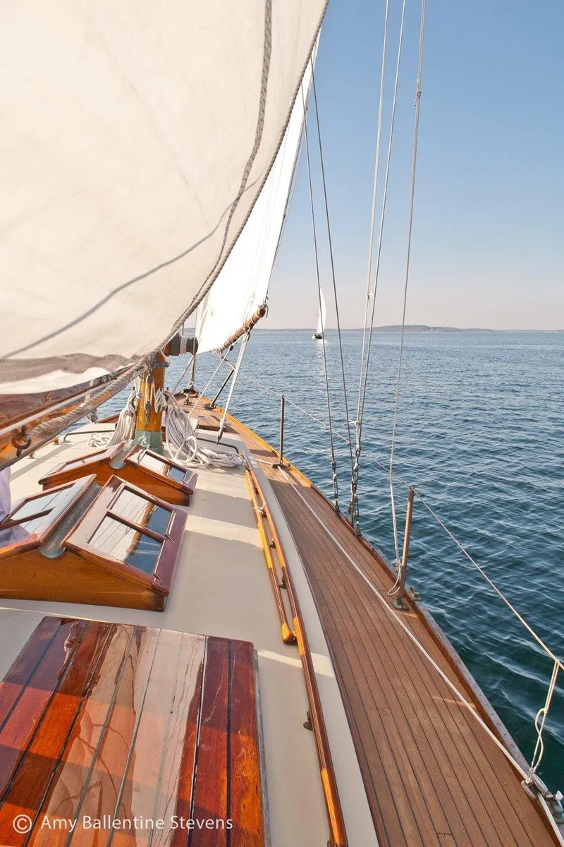 Slide: The Image of 1929 Herreshoff Fishers Island 31 sailboat on calm sea, wooden deck, clear sky. - 20