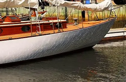 Slide: The Image of 1929 Herreshoff Fishers Island 31 sailboat with wooden deck, docked in calm waters. - 24