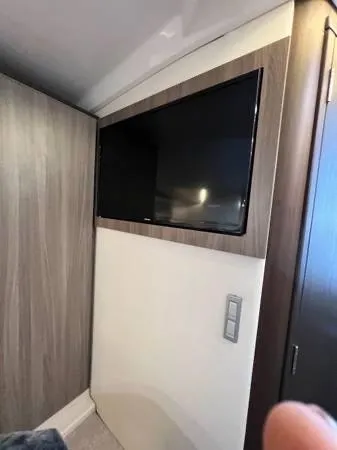 Slide: The Image of Flat-screen TV in the 2023 Regal 36 XO boat interior. - 20