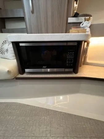 Slide: The Image of Modern kitchen area in 2023 Regal 36 XO yacht with built-in microwave. - 21