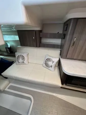 Slide: The Image of Interior of 2023 Regal 36 XO yacht with white leather seating and decorative pillows. - 22
