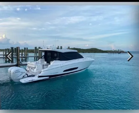 Slide: The Image of 2023 Regal 36 XO boat docked in clear blue water. - 4