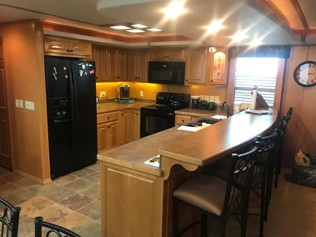 Slide: The Image of Spacious kitchen in a 2007 Thoroughbred houseboat with modern appliances and wooden cabinetry. - 11