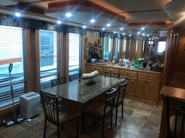 Slide: The Image of Luxurious 2007 Thoroughbred houseboat dining area with granite table, mirrored cabinets, and modern lighting. - 12