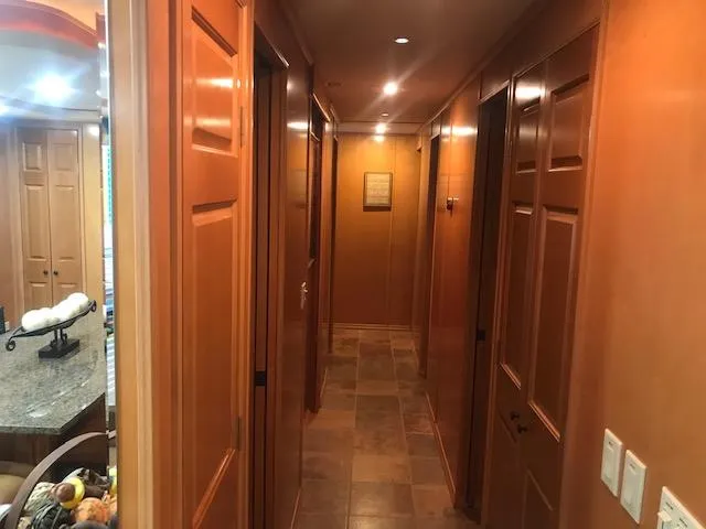 Slide: The Image of Interior hallway of a 2007 Thoroughbred houseboat with wooden doors and tiled floor. - 14