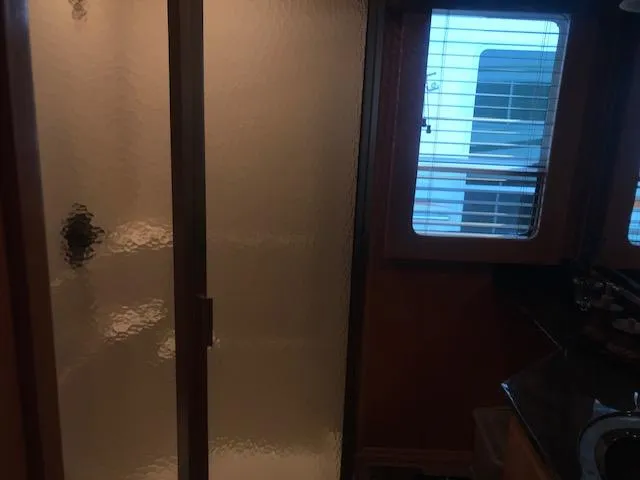 Slide: The Image of Interior of a 2007 Thoroughbred houseboat bathroom with frosted glass shower door. - 15
