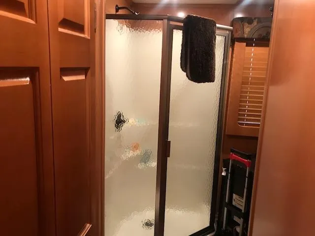 Slide: The Image of 2007 Thoroughbred Houseboat bathroom with frosted glass shower and wooden cabinets. - 17