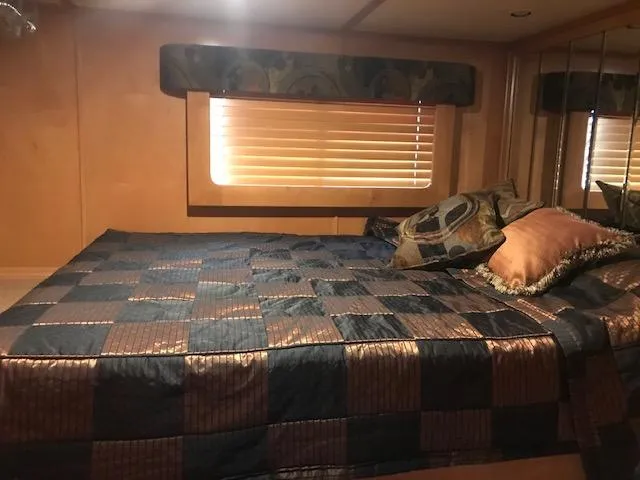 Slide: The Image of 2007 Thoroughbred Houseboat bedroom with a cozy bed and decorative pillows. - 18
