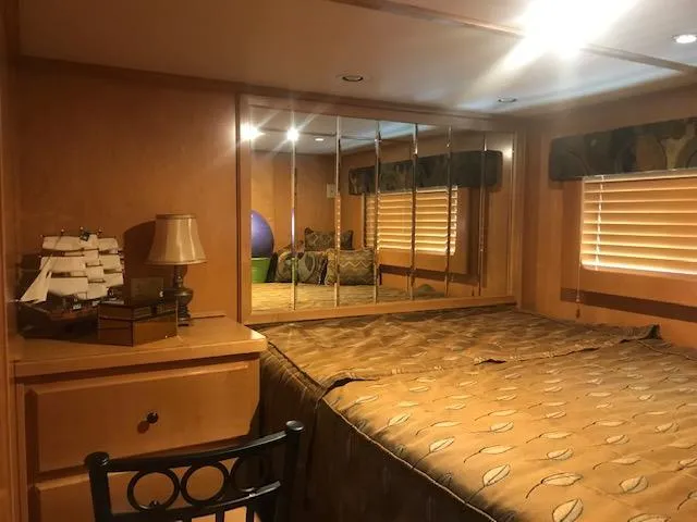 Slide: The Image of Cozy bedroom in a 2007 Thoroughbred houseboat with mirrored closet and wooden furnishings. - 19