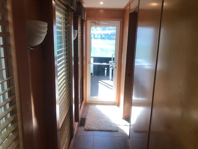 Slide: The Image of 2007 Thoroughbred houseboat interior hallway with wooden paneling and glass door. - 22