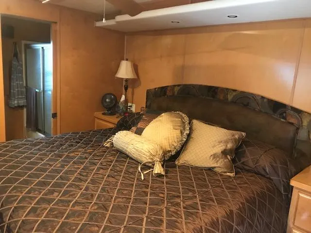 Slide: The Image of 2007 Thoroughbred Houseboat bedroom with a cozy bed, pillows, and bedside lamp. - 24