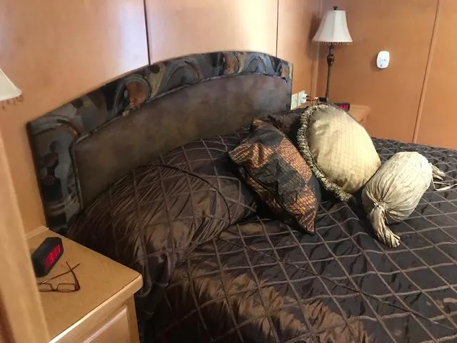 Slide: The Image of Cozy bedroom in a 2007 Thoroughbred houseboat with elegant bedding and bedside lamp. - 26