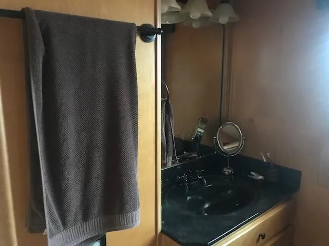 Slide: The Image of Houseboat bathroom with black countertop, mirror, and brown towel. Thoroughbred model, 2007. - 28