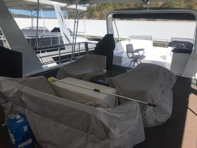 Slide: The Image of 2007 Thoroughbred Houseboat deck with covered furniture and equipment. - 33